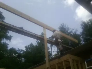 Carpenter setting a ridge beam over a new addition frame — Ice Dam Removal by Roofing Brothers in Two Rivers