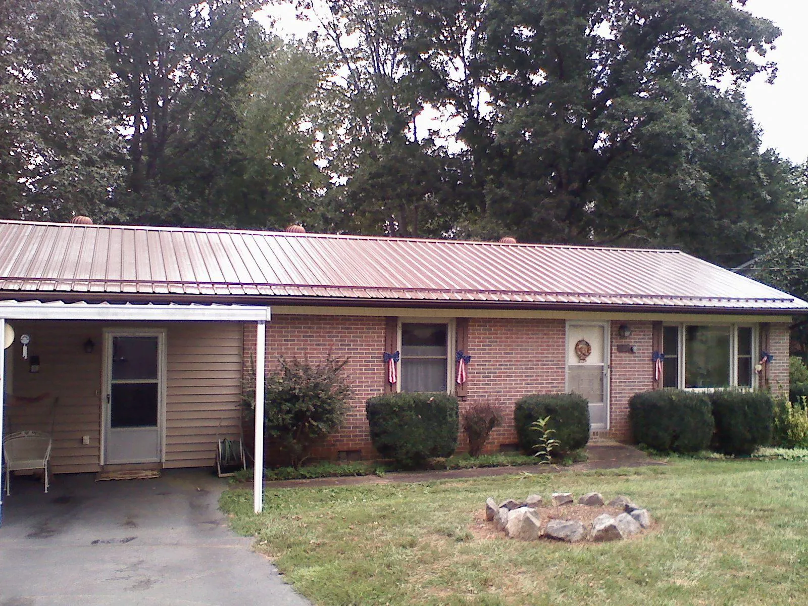 Bronze metal roof and carport on a brick ranch home — Roof Repair work by our crew in Two Rivers